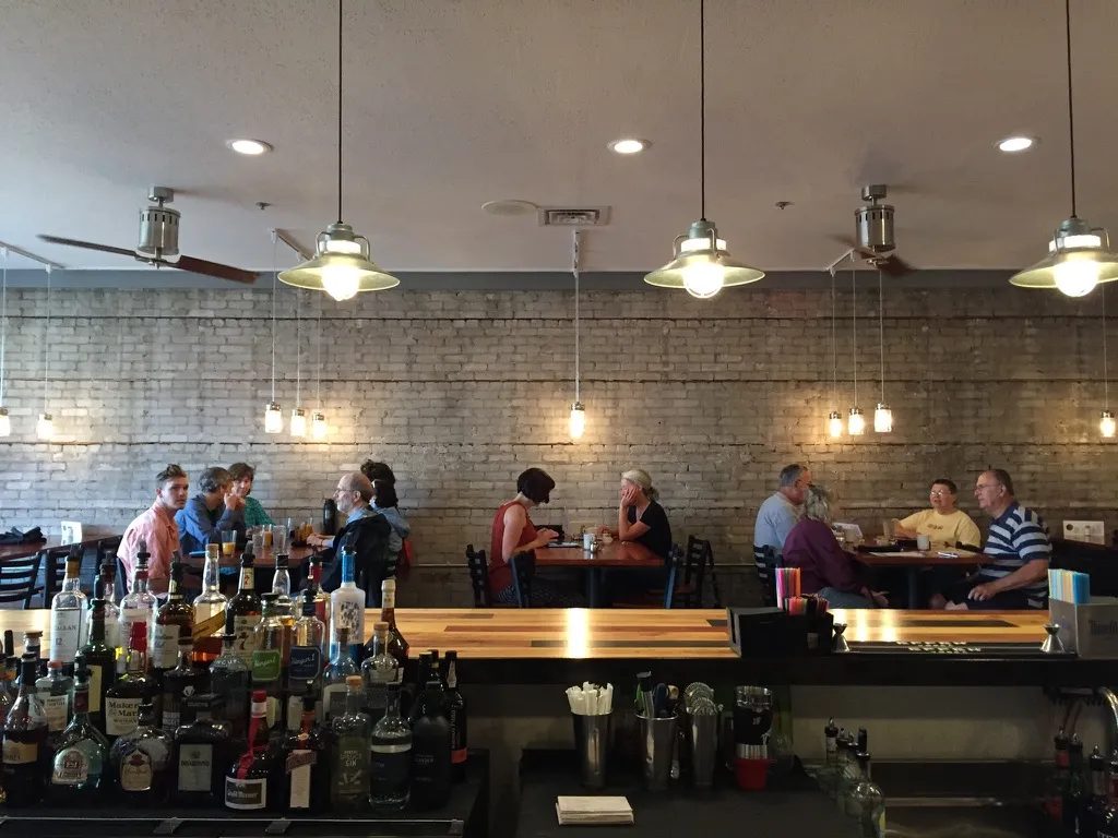 Diners in front of the exposed brick wall