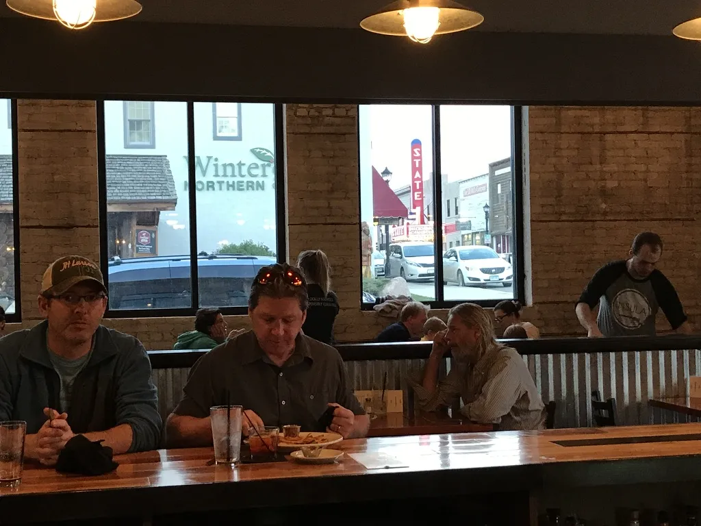 Diners at the bar with the State Theater sign visible through the window