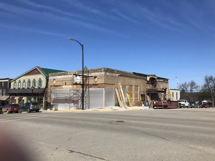 The whole building under construction with lumber and a dumpster