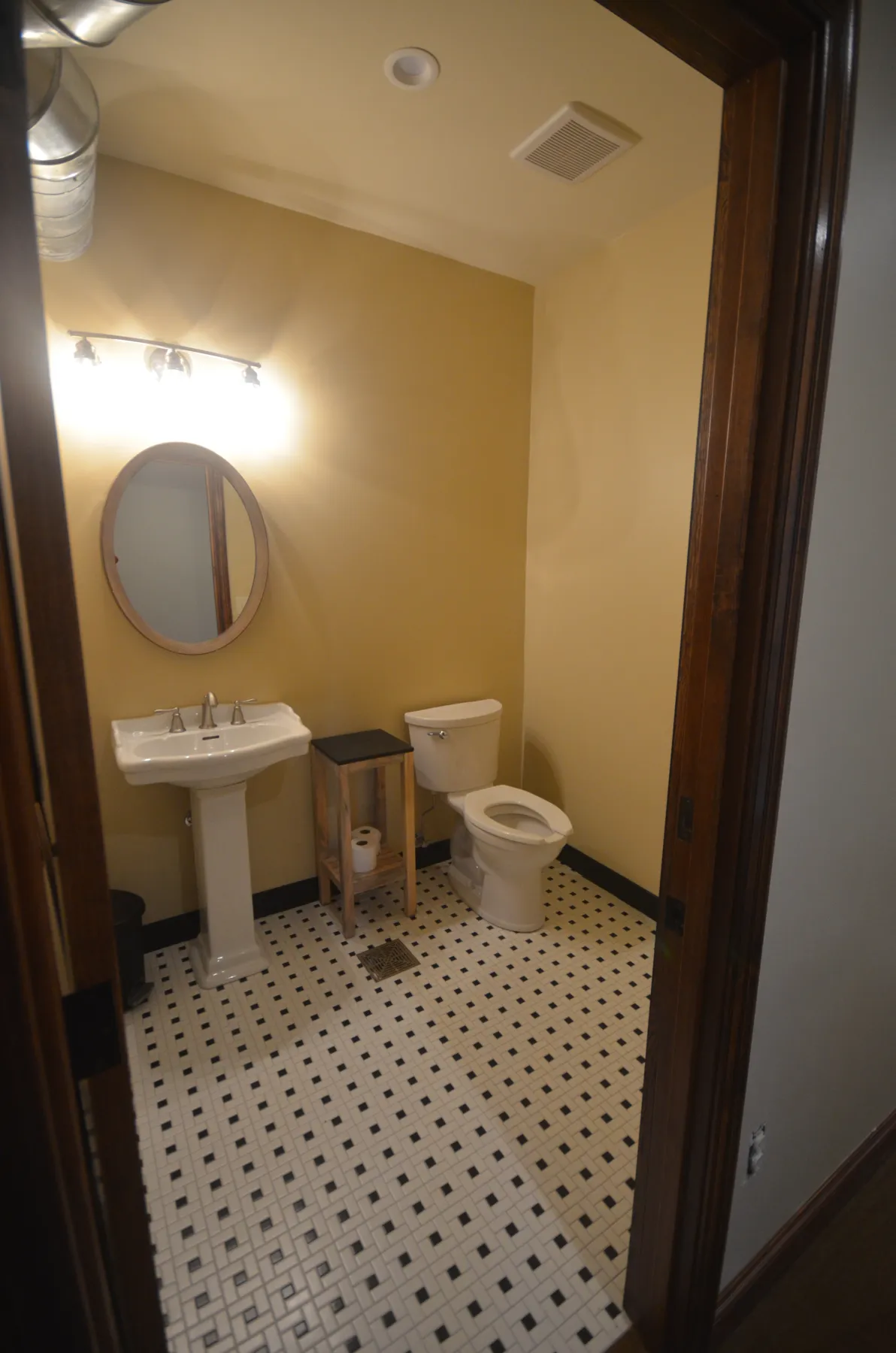 Bathroom with pedestal sink and basketweave tile floor