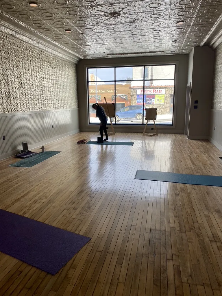 The finished yoga studio with maple floors, tin walls and ceiling and a big front window