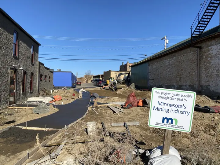 Workers finishing a freshly poured curving concrete path