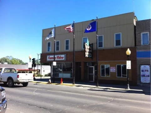The building with metal siding and a Family Video sign, flags out front