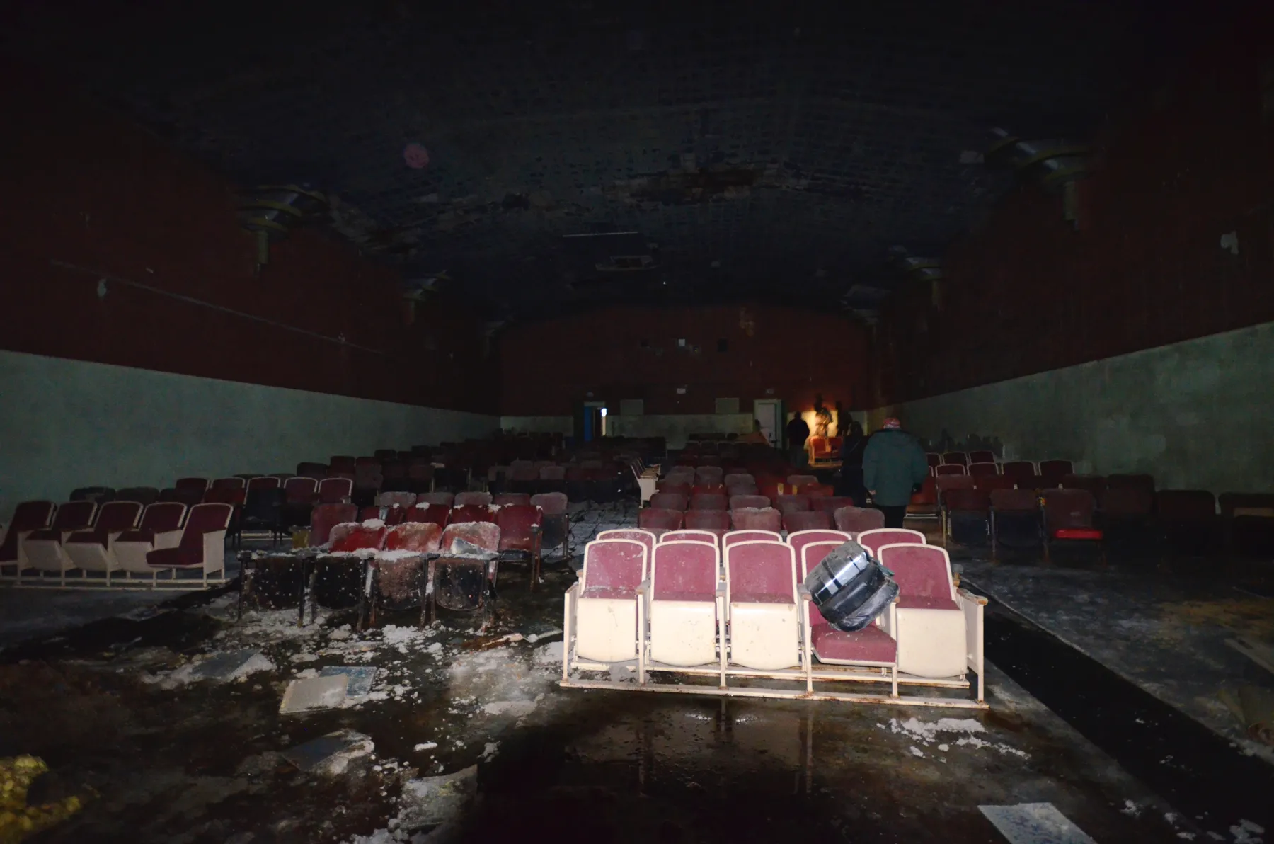 Rows of damaged seats with ice and debris on the floor