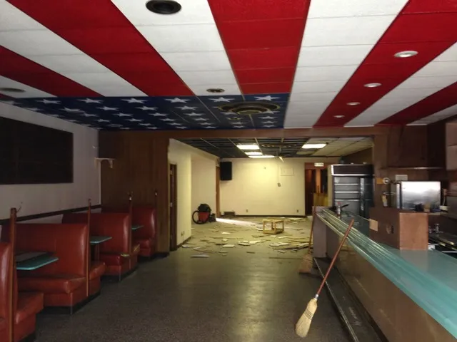 The old club room with red booths, a long bar and a red, white and blue star drop ceiling